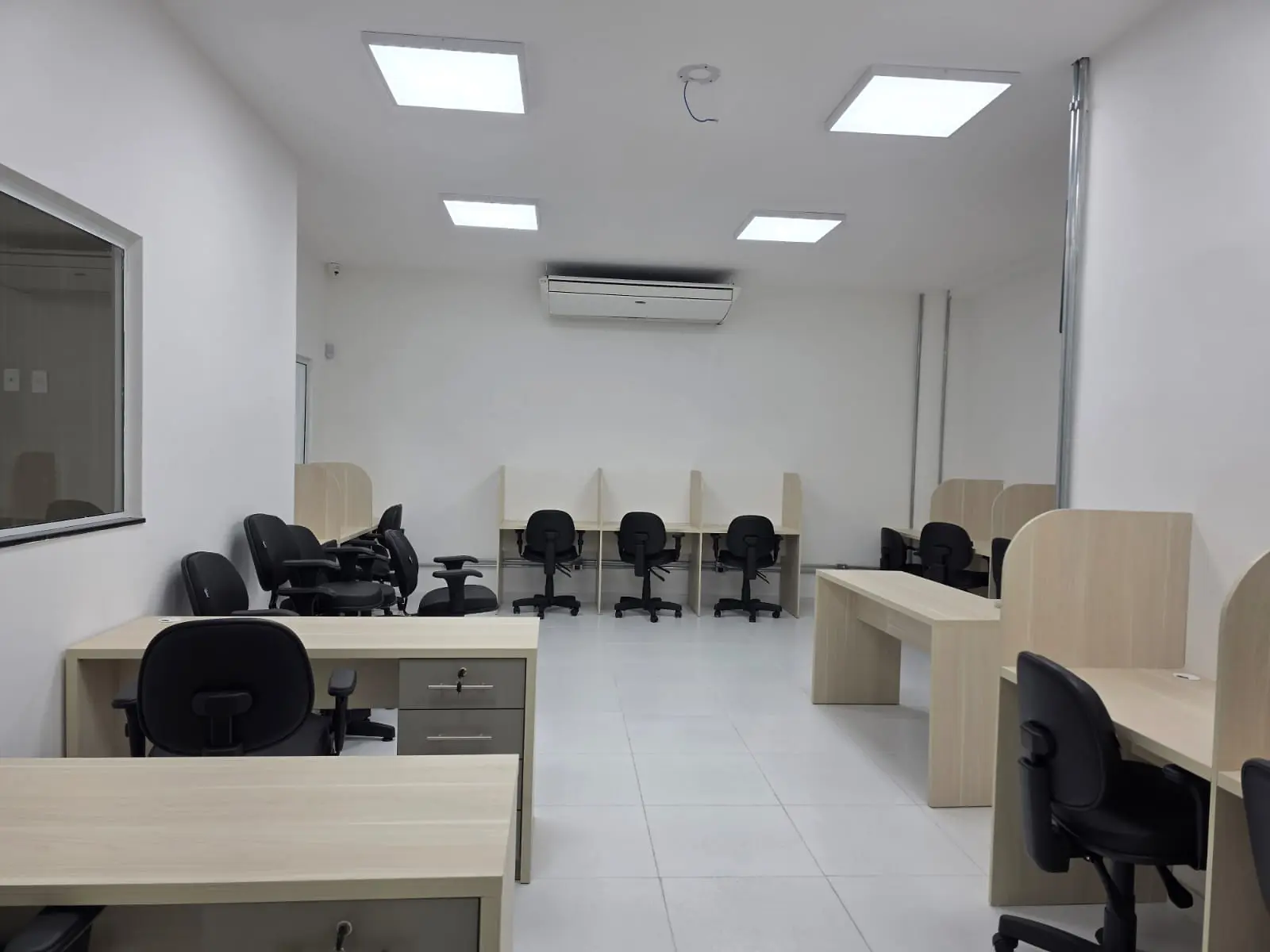 Ambiente administrativo concluído com mesas, cadeiras e iluminação