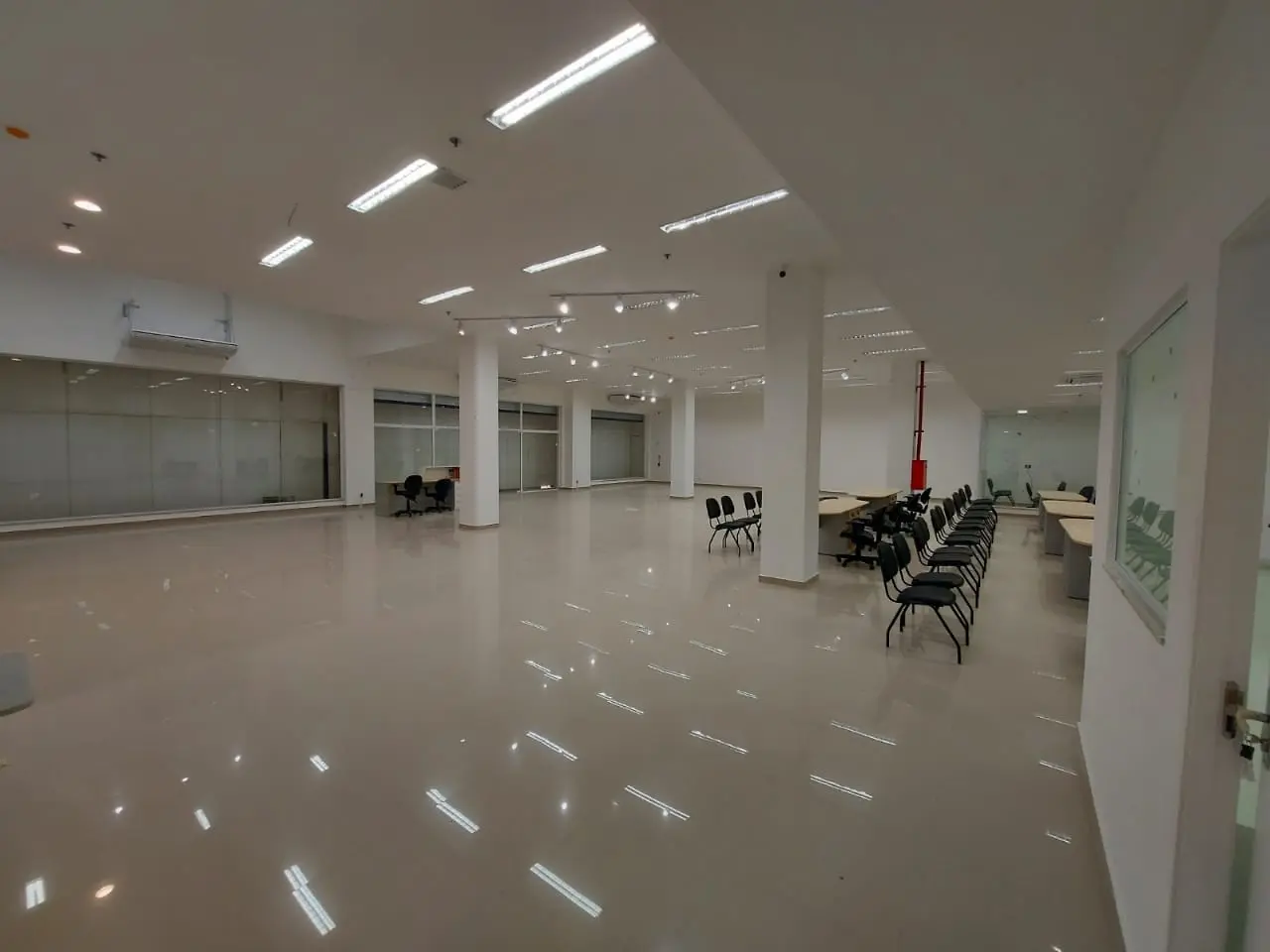 Ambiente comercial amplo, iluminado e com acabamento de piso concluído