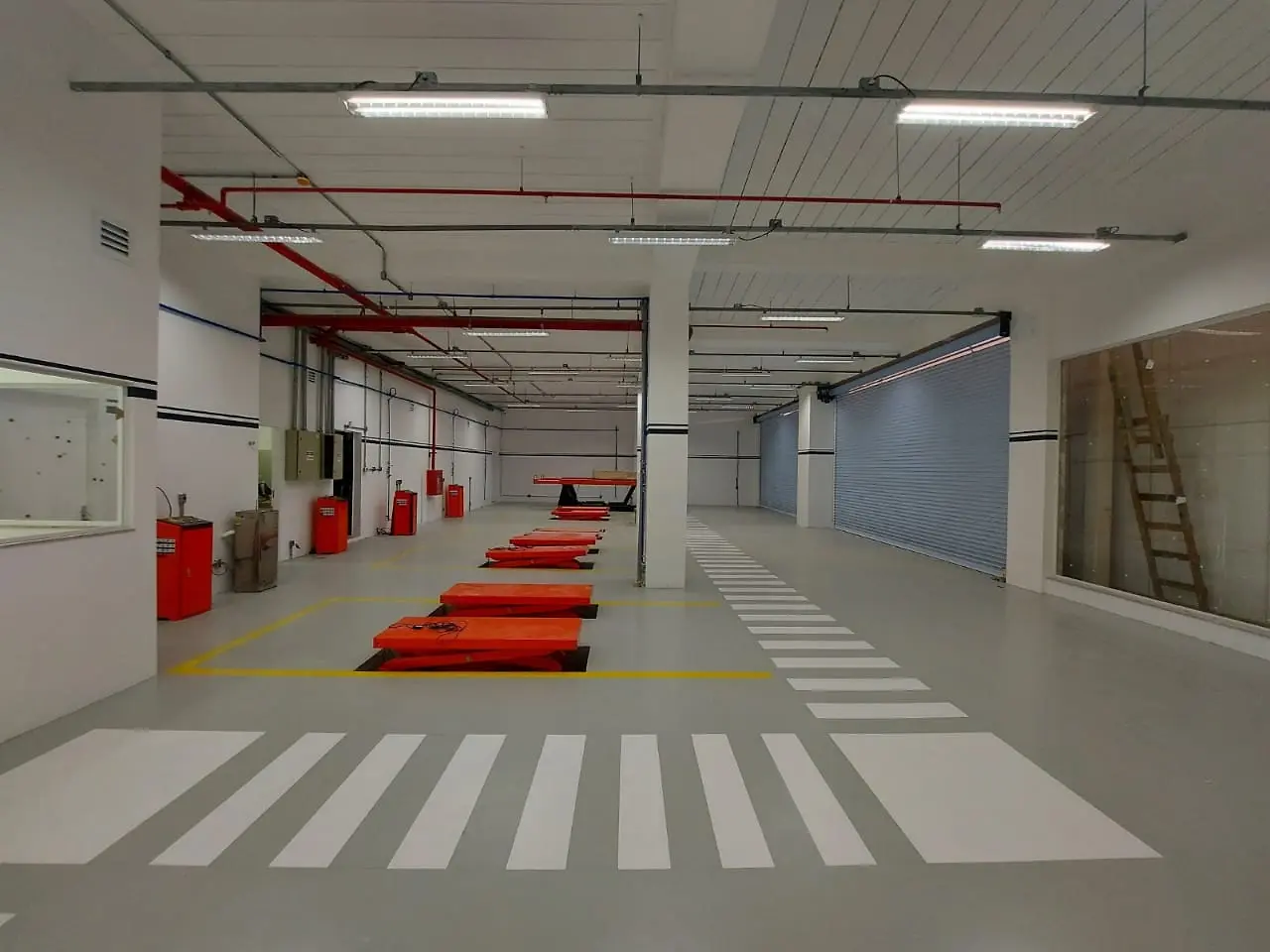 Área técnica concluída, com piso demarcado, equipamentos e instalações aparentes organizadas