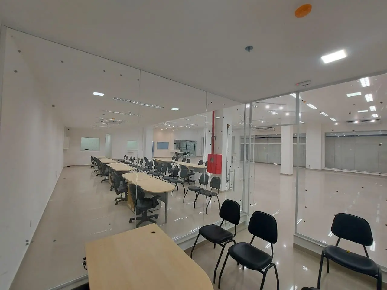 Sala de apoio com divisórias de vidro, mobiliário e iluminação concluídos